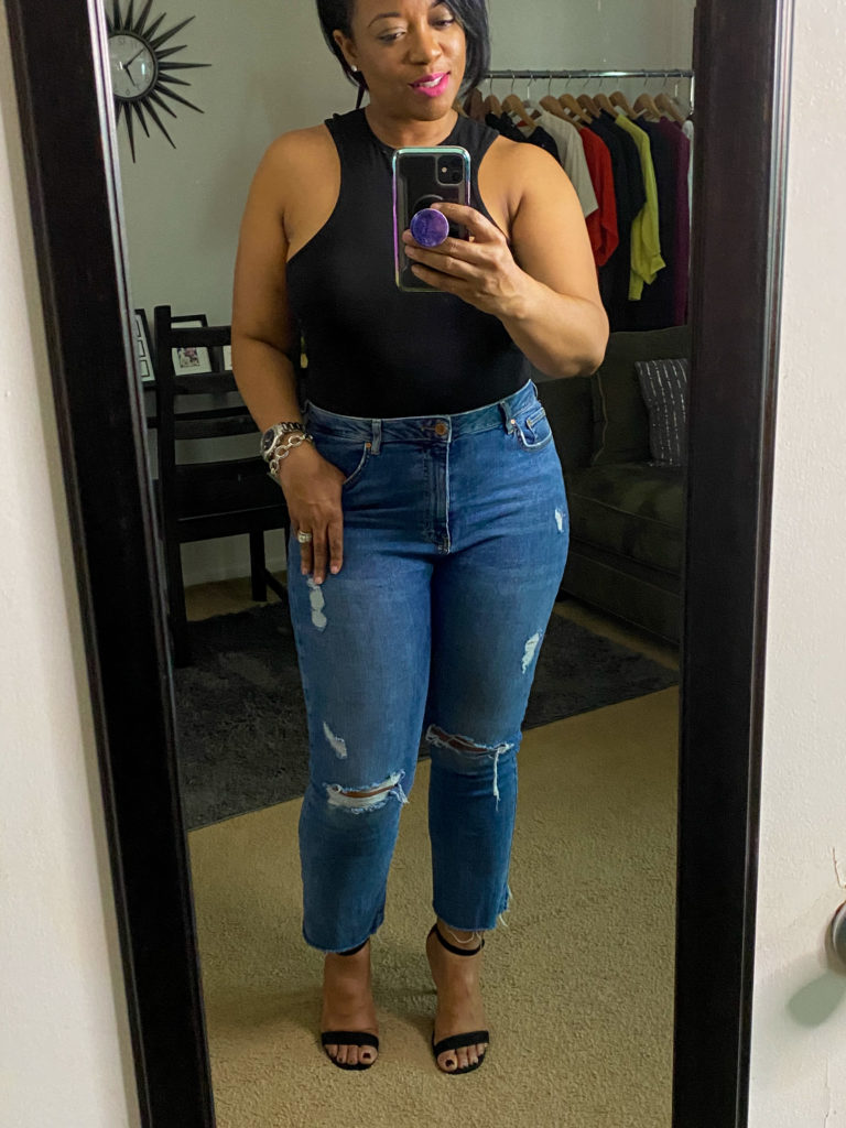 Woman in black body suit and jeans